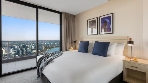 Oaks Brisbane Aurora Suites tesisinde bir odada yatak veya yataklar