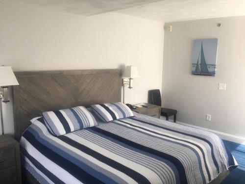 una camera con un letto con una coperta a righe blu e bianche di Rhea's Inn by the Sea a Middletown