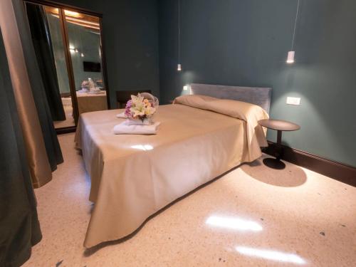 a room with a bed with a table with flowers on it at Residence Poli Venezia in Venice