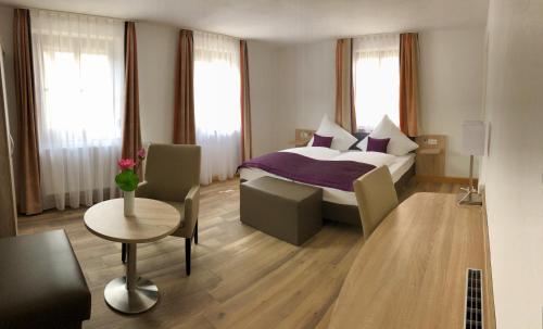 um quarto de hotel com uma cama, uma mesa e cadeiras em A Lotus Hotel em Böblingen