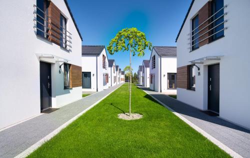 un arbre au milieu d'une rue entre deux bâtiments dans l'établissement Apartamenty Rodzinne Słoneczny Zakątek, à Jastrzębia Góra