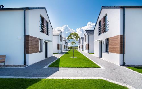 une rangée de bâtiments blancs avec une pelouse verte dans l'établissement Apartamenty Rodzinne Słoneczny Zakątek, à Jastrzębia Góra