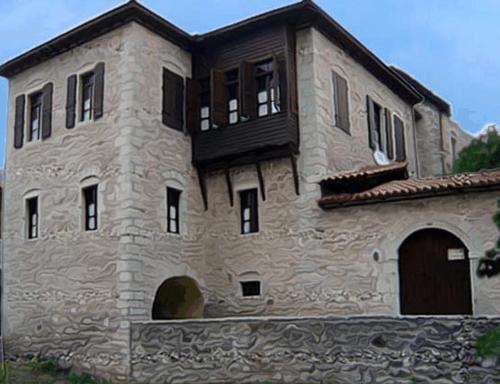 un edificio de piedra con balcón en la parte superior. en Guesthouse Kazakou, en Dhimitsana