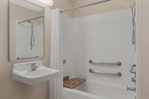 bagno bianco con lavandino e doccia di Candlewood Suites Raleigh Crabtree by IHG a Raleigh