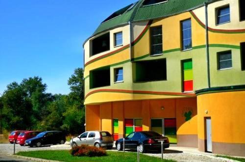 un edificio colorato con auto parcheggiate di fronte di Detelina Complex a Hisarya