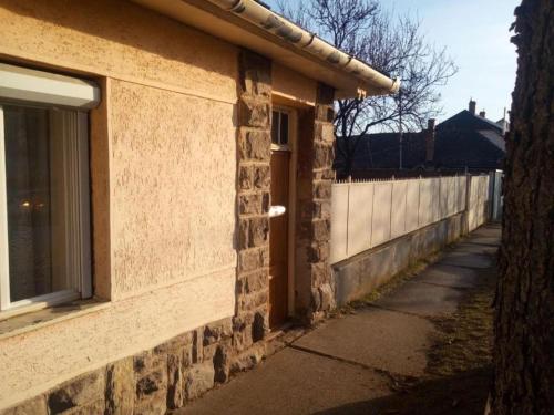 un edificio de ladrillo con una ventana junto a una acera en Gyöngyösi Kertes Ház, en Gyöngyös