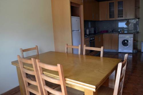 cocina con mesa de comedor de madera y sillas en Casa D'avo, en Gerês