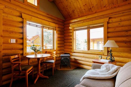 una sala de estar con una mesa en una cabaña de madera en Miette Mountain Cabins, en Jasper