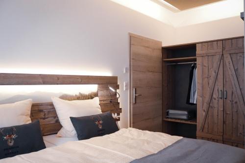 a bedroom with a bed with a wooden headboard and a television at Pension Heimat in Ottenhöfen