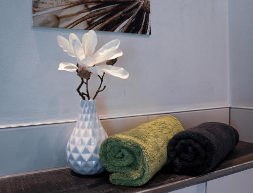 a vase with flowers in it sitting on a shelf at Pension Heimat in Ottenhöfen