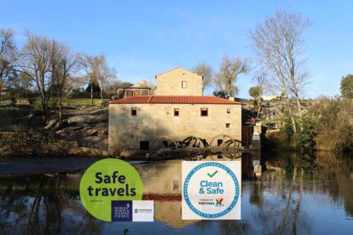 un bâtiment dans l'eau avec deux panneaux dans l'eau dans l'établissement Azenha do Tio Luís, à Caminha