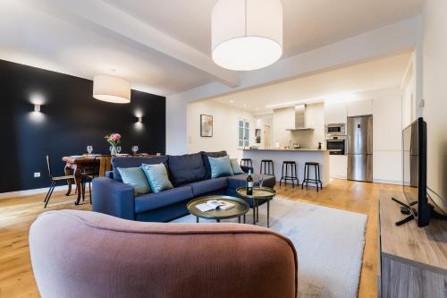 a living room with a blue couch and a table at ZABALETA SUITE by Sweet Home SS Rentals in Donostia-San Sebastián