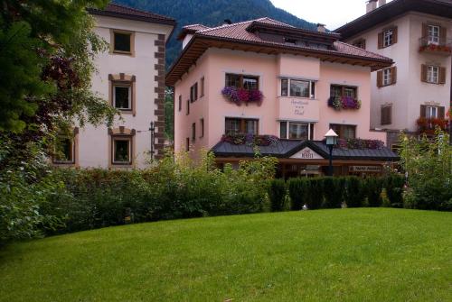 um grande edifício com um relvado verde em frente em Appartements Tlusel em Ortisei