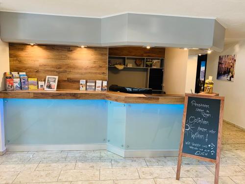 a restaurant with a blue counter with a chalkboard at Hotel Stadt Aurich in Aurich