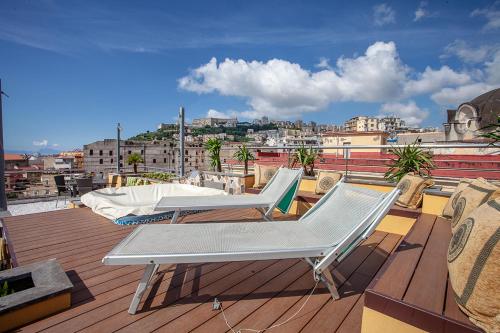 d'un balcon avec deux chaises longues sur le toit. dans l'établissement B&B Nel Regno di Napoli, à Naples