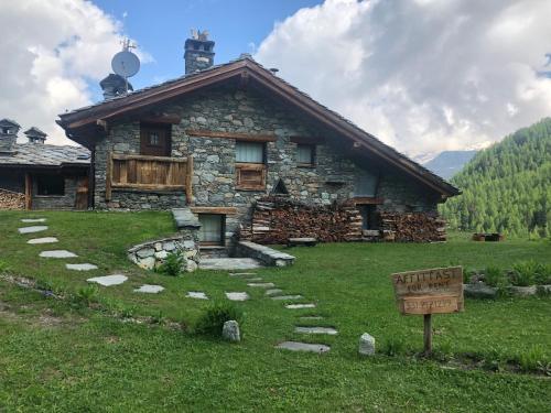 una casa in pietra con un cartello davanti di CHALET GORRET CHENEIL a Valtournenche