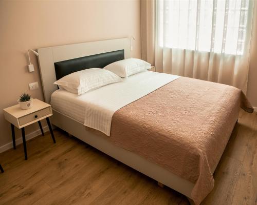 1 dormitorio con 1 cama grande, mesa y ventana en ODA Aparthotel Shkodër, en Shkodër