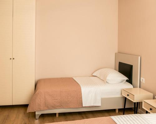 Habitación pequeña con cama y mesita de noche en ODA Aparthotel Shkodër, en Shkodër