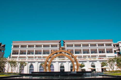 un grand bâtiment blanc avec une arche devant lui dans l'établissement Muine Bay Resort, à Mui Ne