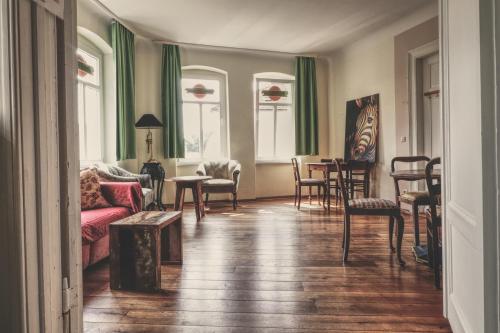 een woonkamer met een bank en een tafel en stoelen bij OPERA Hostel in Erfurt