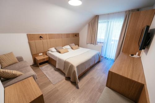 a hotel room with a bed and a couch at Penzion Livada in Kranjska Gora