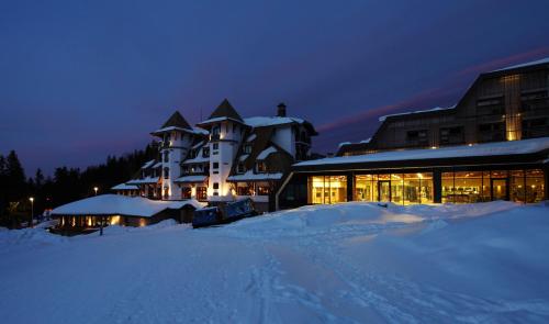 um grande edifício na neve à noite em Termag Hotel Jahorina em Jahorina