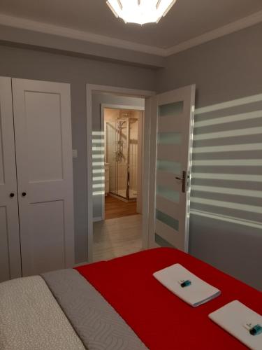 um quarto com uma cama com um cobertor vermelho em Apartament FAMILY- klimatyzacja em Oświęcim