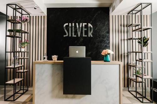 a black and white sign on a wall above a desk with a laptop at Готельно-рестораний комплекс Silver in Ivano-Frankivsʼk