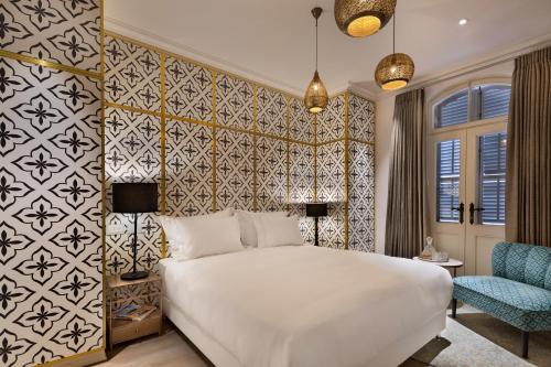 Una cama o camas en una habitación de The Drisco Hotel Tel Aviv - Relais & Châteaux