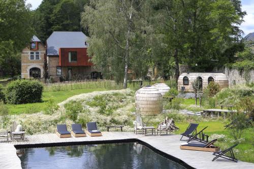 a swimming pool with lounge chairs and a house at Domaine de Ronchinne - Maison du Jardinier in Maillen