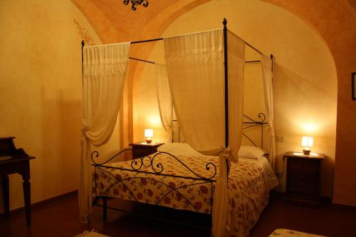 1 dormitorio con 1 cama con dosel y 2 mesitas de noche en Agriturismo La Pisana, en Pisa