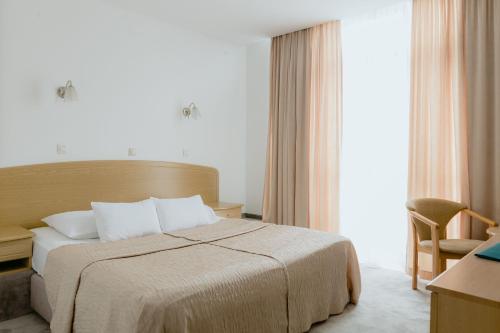 een hotelkamer met een bed en een stoel bij Hotel Silver in Osijek