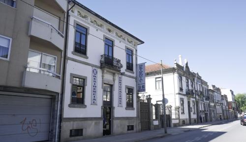 uma fila de edifícios brancos numa rua da cidade em Hotel Portucalense no Porto