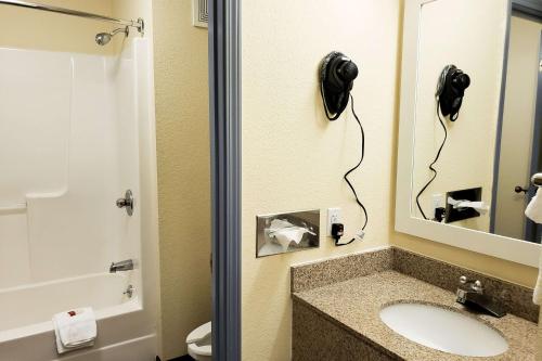 bagno con lavandino e specchio di Days Inn & Suites by Wyndham Merrillville a Merrillville