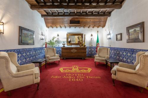 una sala d'attesa con sedie e specchio di Hotel Sao Joao De Deus by RIDAN Hotels a Elvas