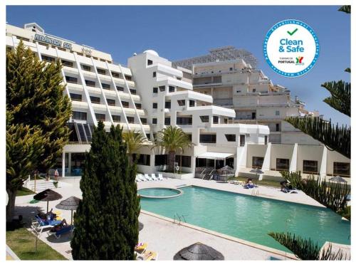 um grande edifício de apartamentos com uma piscina em frente em Hotel Atlantida Sol na Figueira da Foz