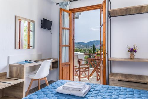 een kamer met een bed, een bureau en een raam bij Nepheles in Skopelos Town