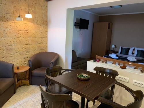 Guest Accommodation Zone في نيسكا بانجا: غرفة معيشة مع طاولة وكراسي خشبية