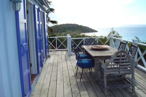 a wooden deck with a table and chairs on a balcony at Aloe Villa in Five Islands Village