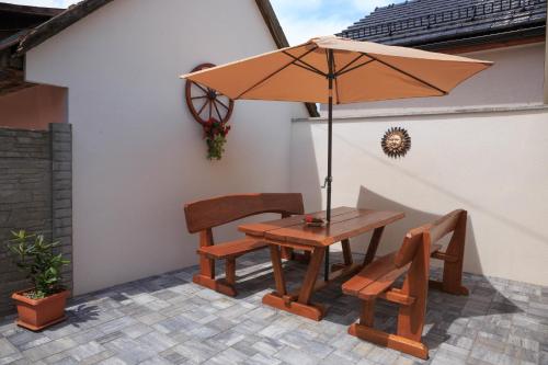 een tafel en twee stoelen en een parasol op een patio bij Villa Michaela in Bešeňová