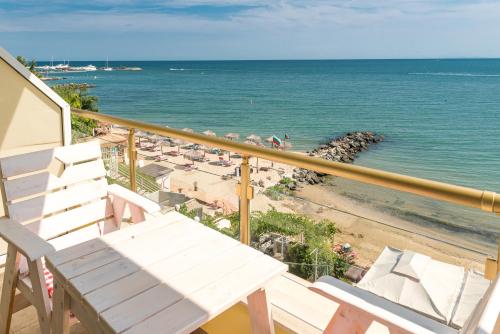 einen Balkon mit einer Bank und einem Strand in der Unterkunft Iris Beach Hotel in Sweti Wlas