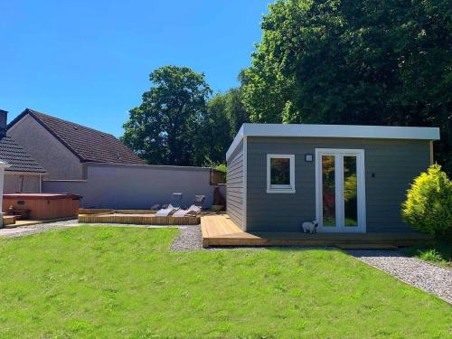 a tiny house in a backyard with a yard at Highland HotTub Retreat, on NC500 in Inverness