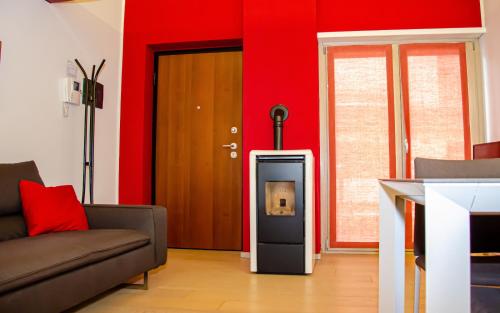 sala de estar con chimenea y pared roja en Holiday House Viola, en Tirano