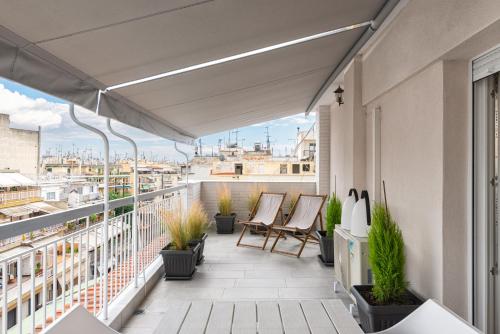 d'un balcon avec des chaises et une vue sur la ville. dans l'établissement White Suite Armonia, à Thessalonique