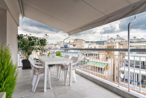 d'une table et de chaises blanches sur un balcon avec vue. dans l'établissement White Suite Armonia, à Thessalonique