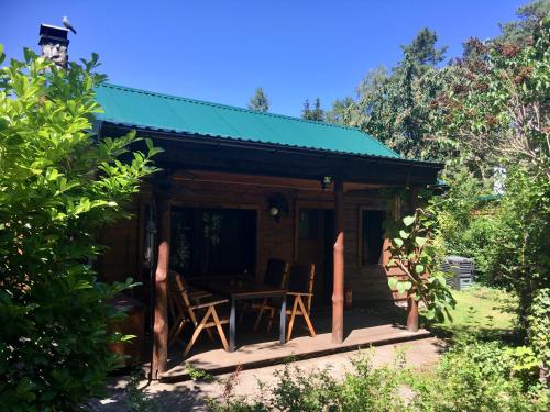 een huisje met een tafel en stoelen in de tuin bij Norwegisches Holzhaus in Neuruppin