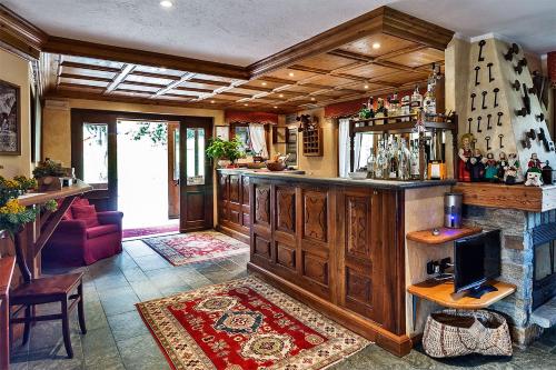 Zimmer mit einer Bar mit Sofa und einem TV in der Unterkunft Hotel Lo Campagnar in Courmayeur