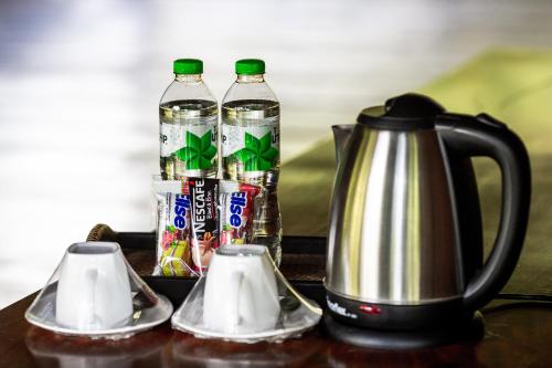 een tafel met 2 flessen water en een waterkoker bij Ruan Kanchanok in Pak Chong