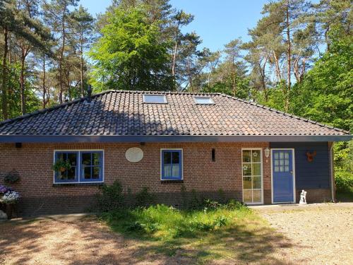 ein kleines rotes Backsteinhaus mit blauen Türen und Fenstern in der Unterkunft Holiday home bos en heide in Otterlo