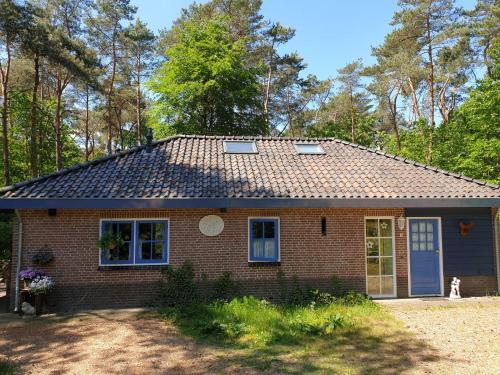 ein kleines Backsteinhaus mit einem Dach in der Unterkunft Holiday home bos en heide in Otterlo